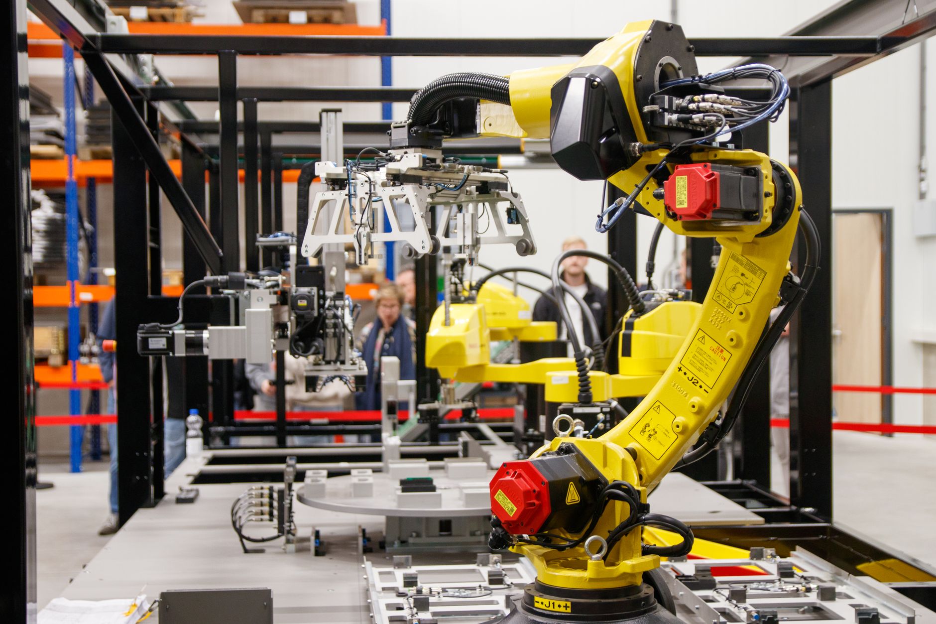 Gros plan d'un bras robotique industriel jaune en action dans une usine de fabrication moderne.