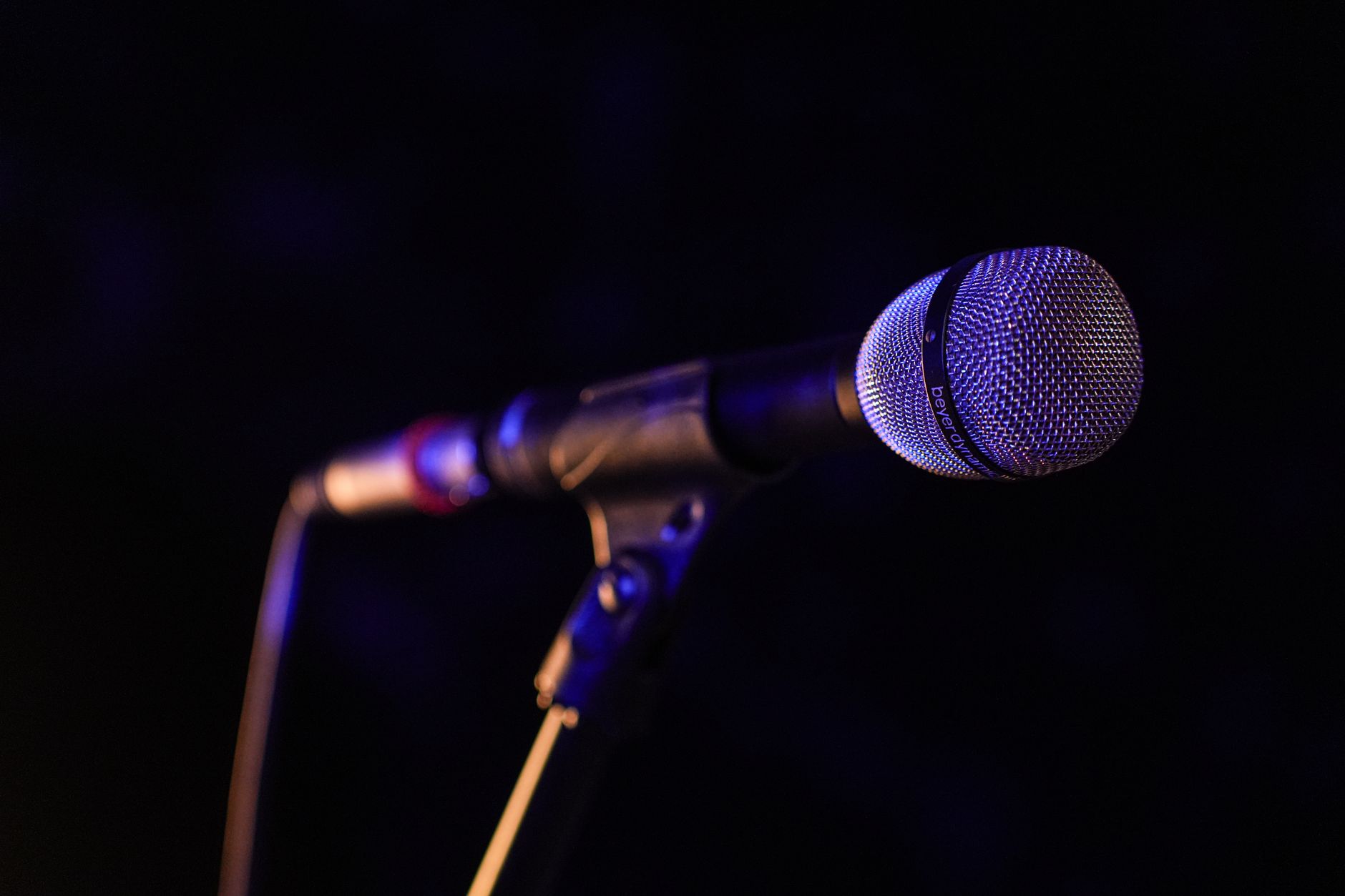 Gros plan sur un microphone sur scène, photo d'illustration générique sur le thème du concert.