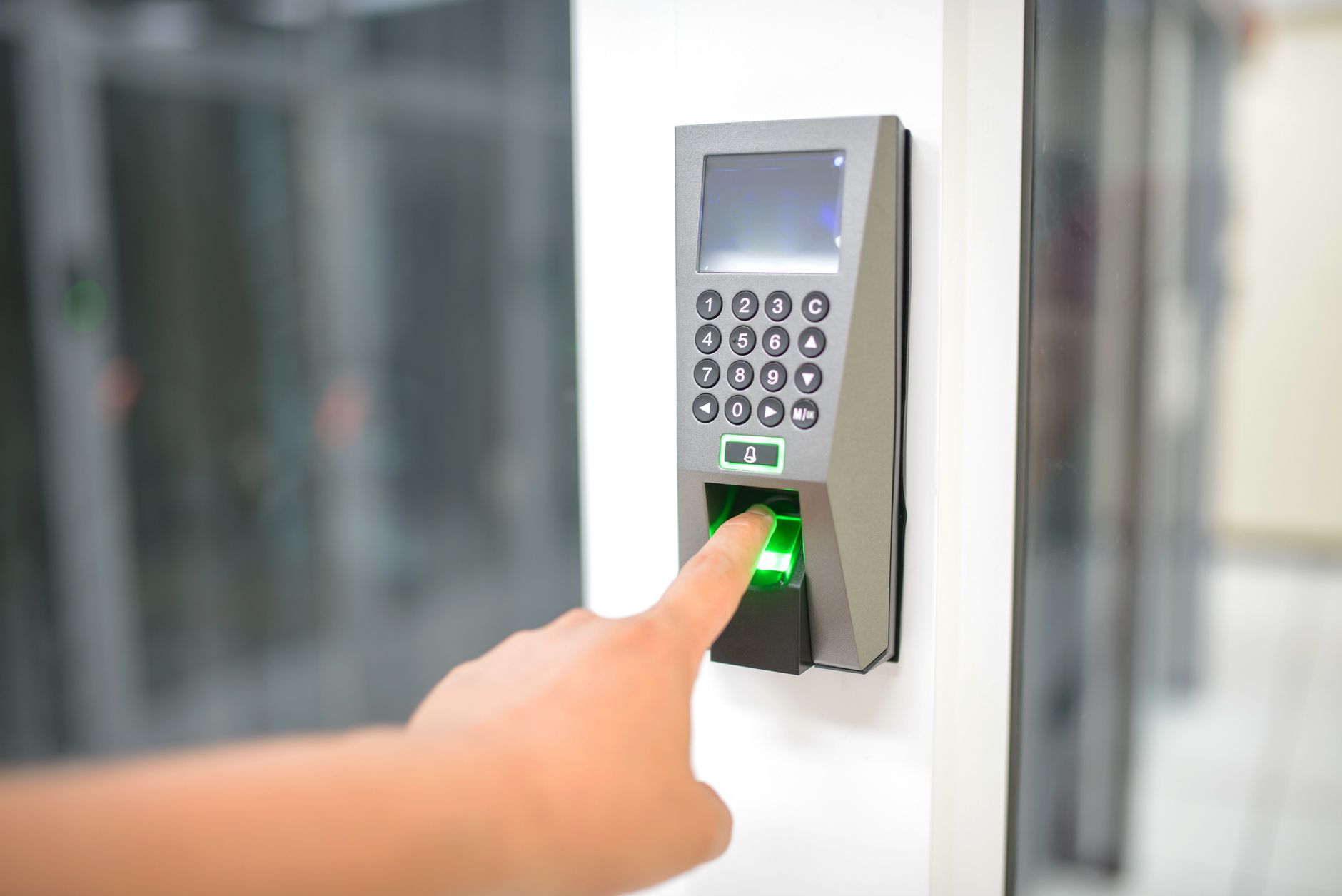 Une personne utilise un scanner d'empreintes digitales pour un accès sécurisé dans un environnement professionnel.