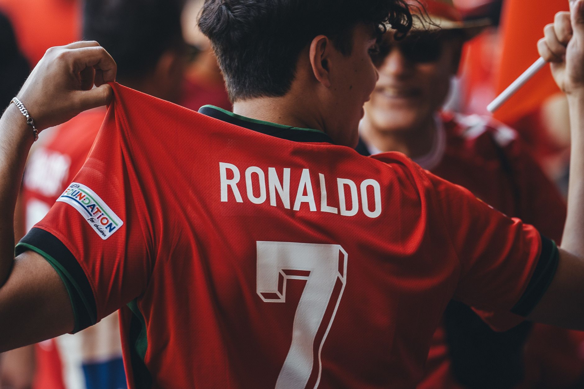 Un fan de football passionné portant un maillot de Ronaldo célèbre lors d'un événement sportif.