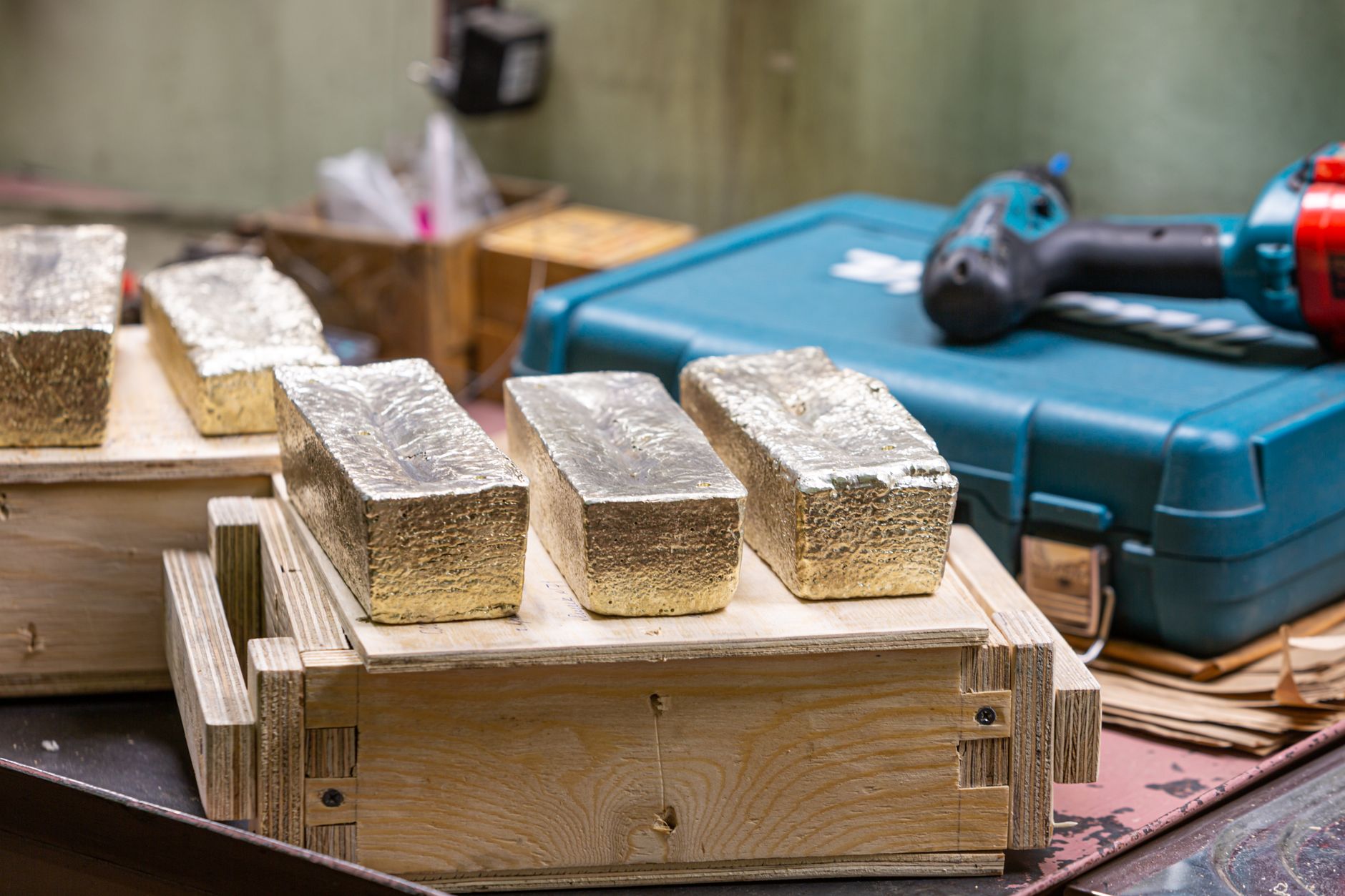 Barres d'or dans un atelier, mettant en avant le travail du métal et les thèmes industriels.